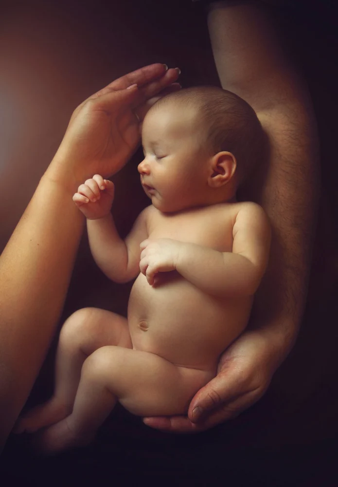 Neonato addormentato sostenuto dalle mani di un adulto — Veronica Garavaglia