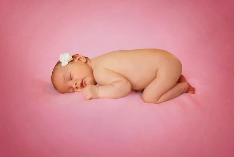 Neonato addormentato di fianco su fondo rosa — Veronica Garavaglia