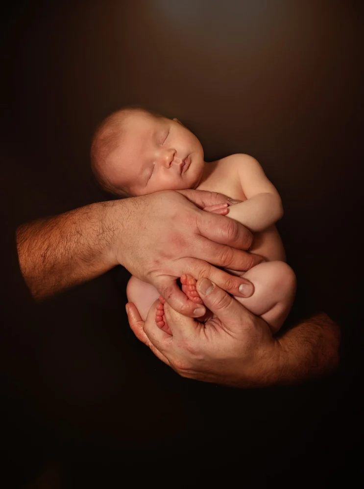 Neonato addormentato raccolto tra due mani — Veronica Garavaglia