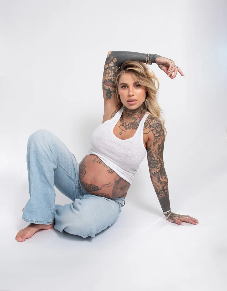 Donna in attesa seduta con jeans e camicia bianca — Veronica Garavaglia