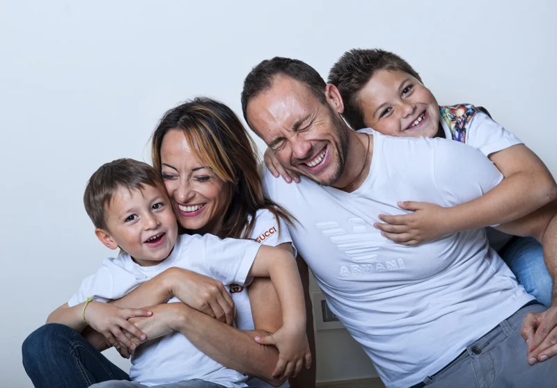Famiglia con due bambini abbracciati — Veronica Garavaglia